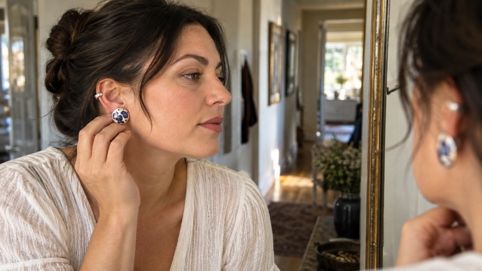Person with a broader jaw trying a compact blue-and-white clip-on statement earring with a silver ear cuff.